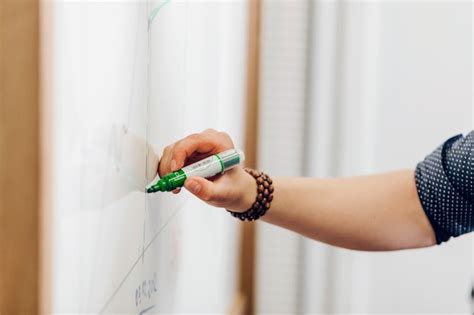 Man holding marker pen writing on whiteboard Photo | Free Download