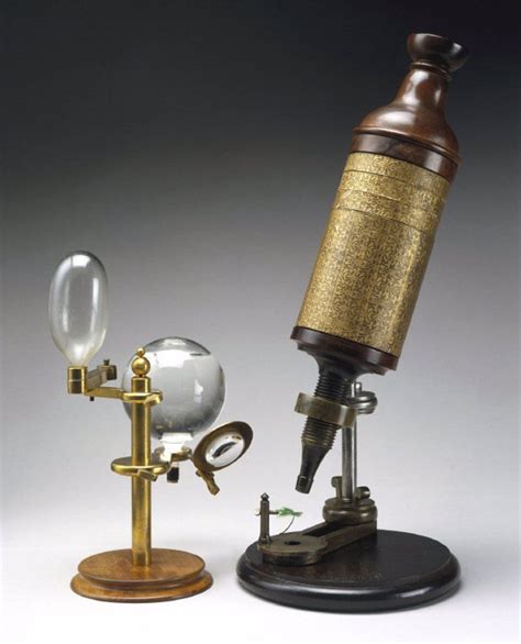 an old fashioned microscope and glass globe on a stand