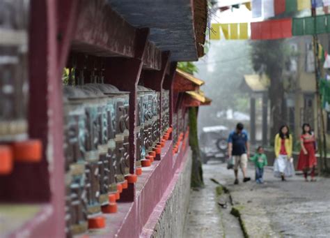 Gangtok locals come to pray walking between the prayer wheels and prayer flags en route to ...