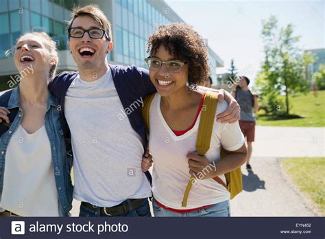 Laughing college students hugging on campus Stock Photo - Alamy