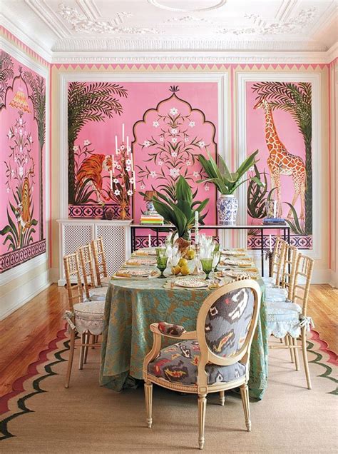 a dining room decorated in pink and green with giraffes on the wall