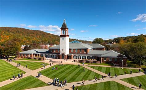 an aerial view of people walking around in front of a building with a clock tower