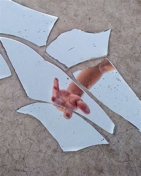 Mirror Fragments on Gray Surface With The Reflection Of A Person"s Arm ...