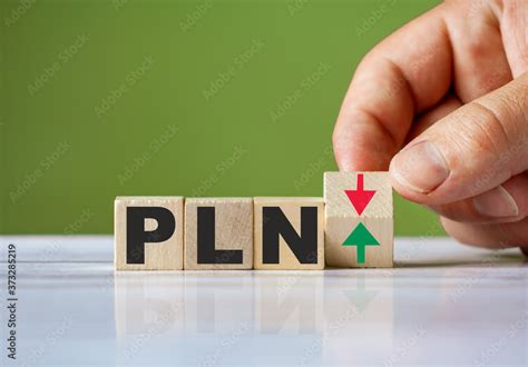 Word PLN currency symbol concept and hand turn wooden block and change red arrow to green or ...