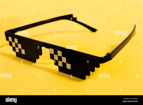 Close up view of meme pixel glasses isolated on a yellow background Stock Photo - Alamy