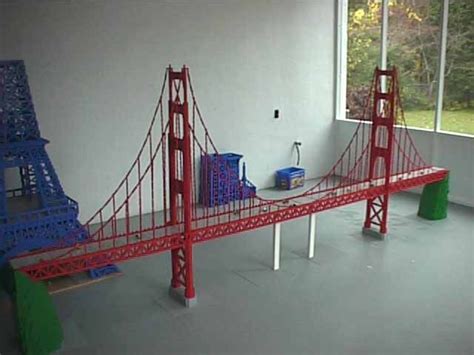 a model of the golden gate bridge is displayed in a room with two large windows