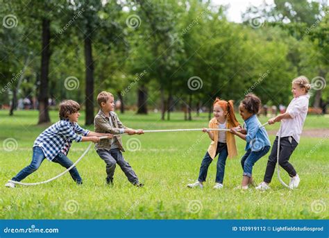 Kids playing tug of war stock photo. Image of friends - 103919112