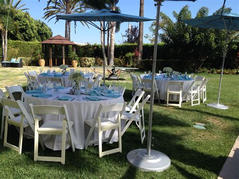 an outdoor dining area with tables and umbrellas set up in the grass ...