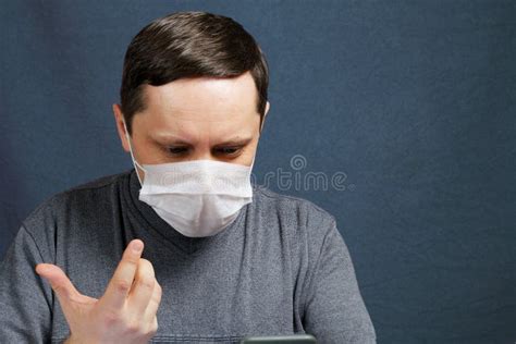 A Man in a Medical Mask is Talking on a Smartphone, Video Conferencing ...