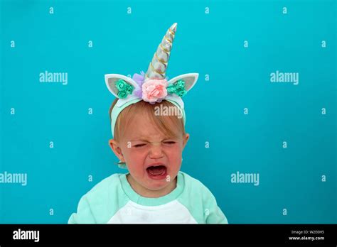 Crying baby in unicorn costume Stock Photo - Alamy