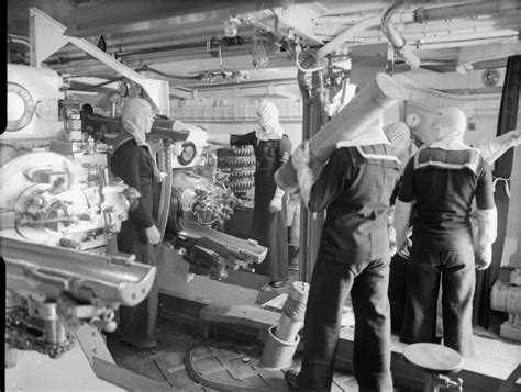 The interior of a 6 inch triple Mark XXIII mounting on board HMS Jamaica. Note the crew wearing ...