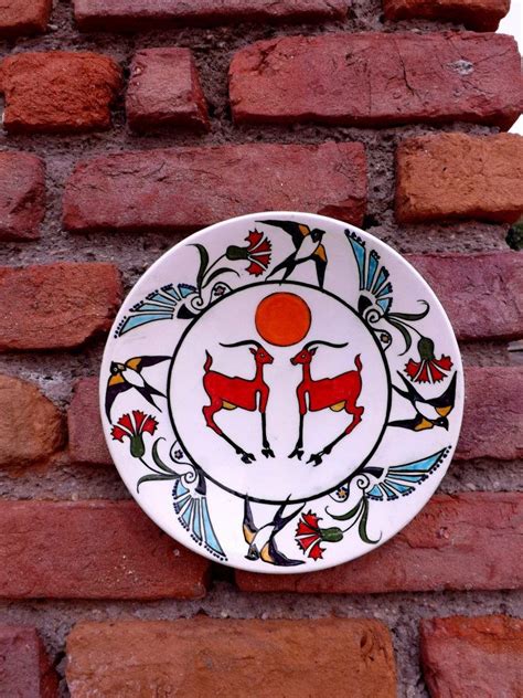 a white and black plate sitting on top of a brick wall