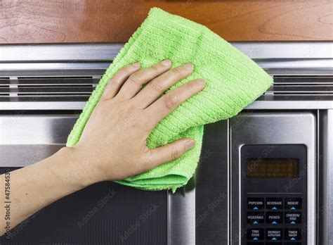 Cleaning Kitchen Appliance Fan Vents on Microwave Oven Stock Photo ...