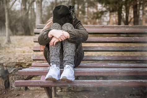 Sad depressed young girl sitting on a bench in a - stock photo 1903465 ...