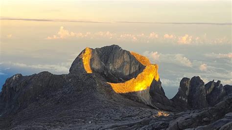 Sun Forms 'Golden Halo' On Mount Kinabalu Peak, Resembles A Gold Dragon Resting Amongst Clouds