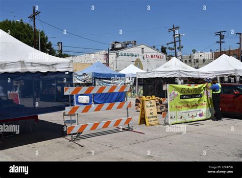 Los Angeles, CA USA - June 24, 2021: Man hanging banner for the Echo Park Farmers Market at the ...