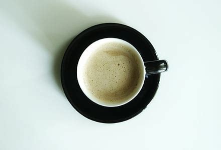 Royalty-Free photo: Bubbly coffee served on white ceramic coffee mug | PickPik