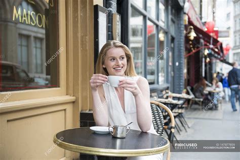 Woman sitting outside cafe — place, england - Stock Photo | #147877859