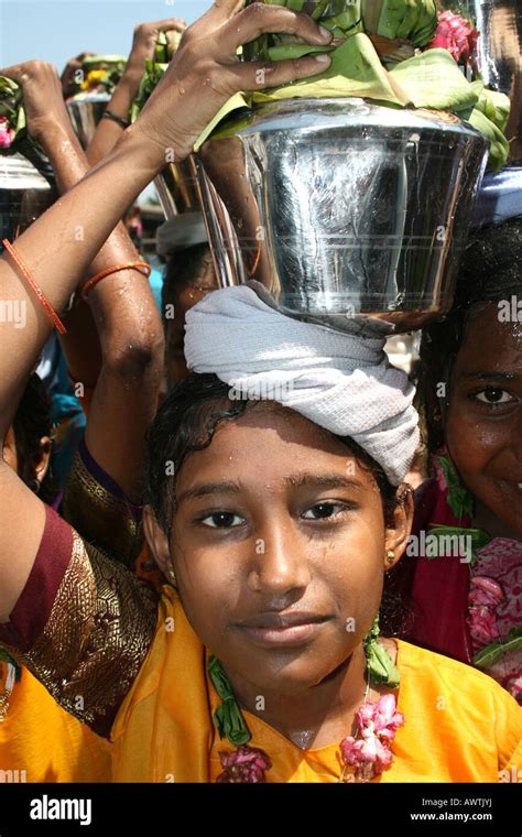 Village children carry metal pot of water and tumeric from the water to a temple in honour of ...