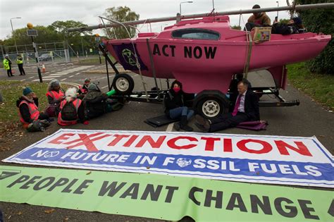 In pictures as Fawley Extinction Rebellion protestors climb onto large 50ft oil silos during ...