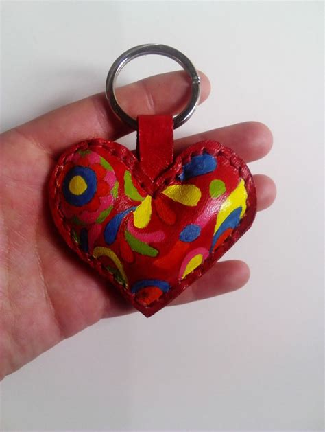a hand holding a red heart shaped keychain