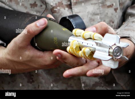 A US Marine holds a 60 mm mortar rounds from M-224 Mortar Systems ...