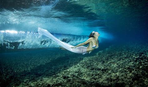 A photographer has captured models swimming through the ocean dressed ...