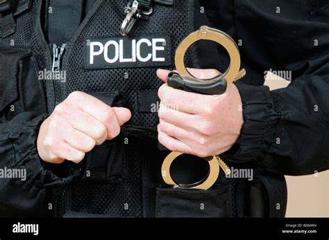 Police officer holding handcuffs hi-res stock photography and images - Alamy