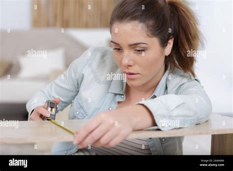 a woman measures a wood plank Stock Photo - Alamy