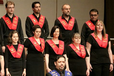Group of People in Choir Uniforms with Red Sashes