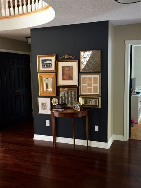 Benjamin Moore Wrought Iron gallery wall with gold frames | Black accent wall living room ...