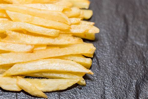 French fries on black background - Creative Commons Bilder