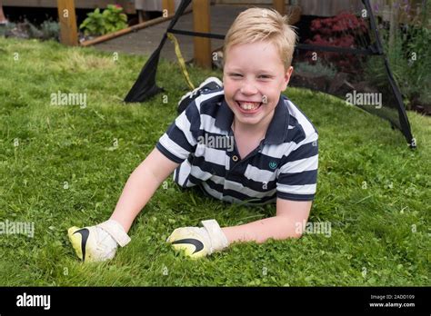 Boy with cerebral palsy. 10-year-old boy with cerebral palsy playing football in his garden ...