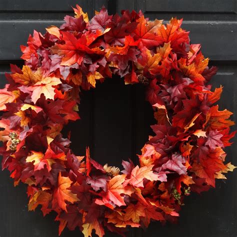 This fall leaf wreath is full of artificial fall leaves in hues of deep red, vibrant orange, go ...