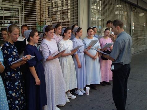 a group of people standing next to each other in front of a building ...