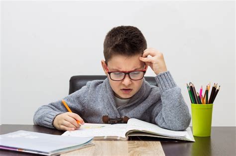 Free Photo | Young boy frustrated over homework, writing at home. Boy studying at table. Kid ...