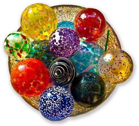 there are many different colored glass balls in the bowl