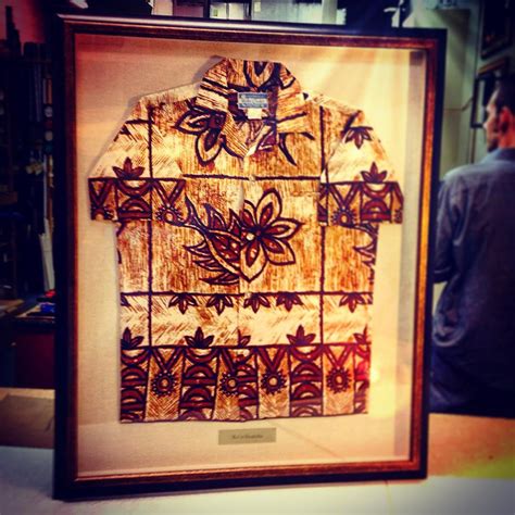 Hawaiian shirt shadowboxed with a linen mat behind and lining the sides of the frame. The frame ...