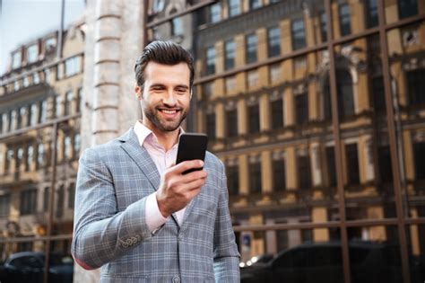 Free Photo | Happy handsome man in jacket looking at mobile phone