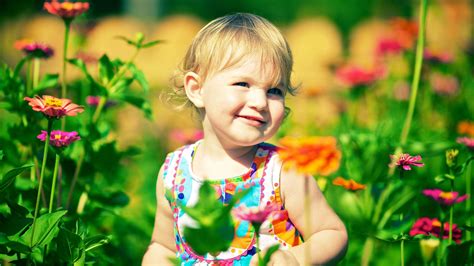 Download Smiling Child In A Flower Garden Wallpaper | Wallpapers.com