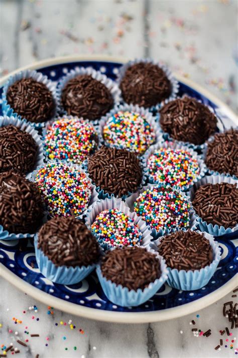 chocolate cupcakes with sprinkles in a blue and white plate on a marble ...