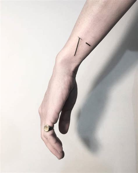 Minimalist V letter tattoo on the wrist.