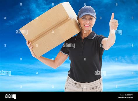 Composite Image Of Happy Delivery Woman Holding Cardboard Box Stock