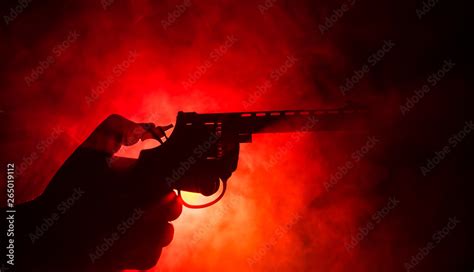 Male Hand Holding Gun On Black Background With Smoke Toned Back Lights