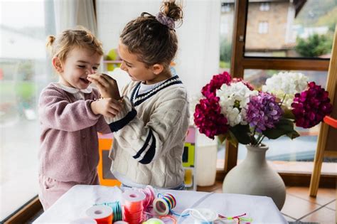 escena de dos ninas divirtiendose jugando  artesanias en la sala de