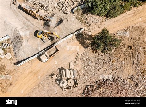 Excavator Loading Crushing Stone Into A Dump Truck Aerial Top View Of