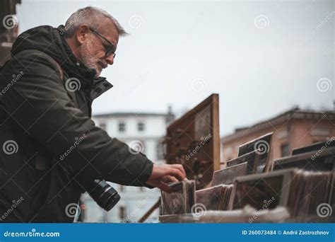 Mature Collector Chooses Rare Vintage Vinyl Audio Recordings At A Flea Market Stock Photo
