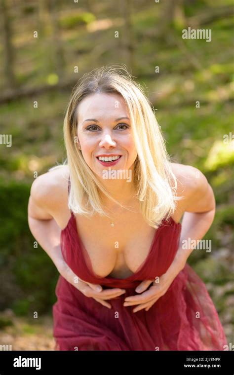 Portrait de femme blonde sensuelle portant sexy élégante robe magenta montrant le clivage tout