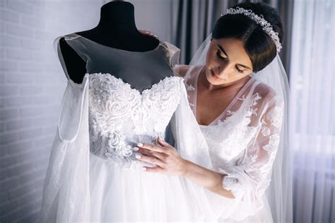 Linda noiva em lingerie pela manhã antes da noiva em um roupão abraçar e tocar o vestido no