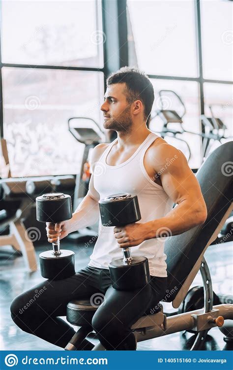 Homem Muscular Determinado Que Exercita Pesos Foto De Stock